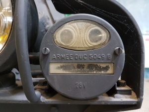 Picture of the light cluster from a ww2 military car that looks as if it has two eyes and a face.