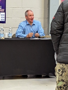 Chris Barrie sitting at a table