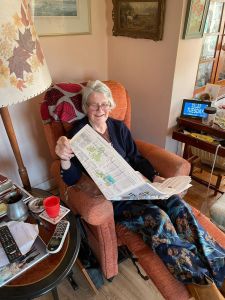Picture of a lady in a chair reading a newspaper